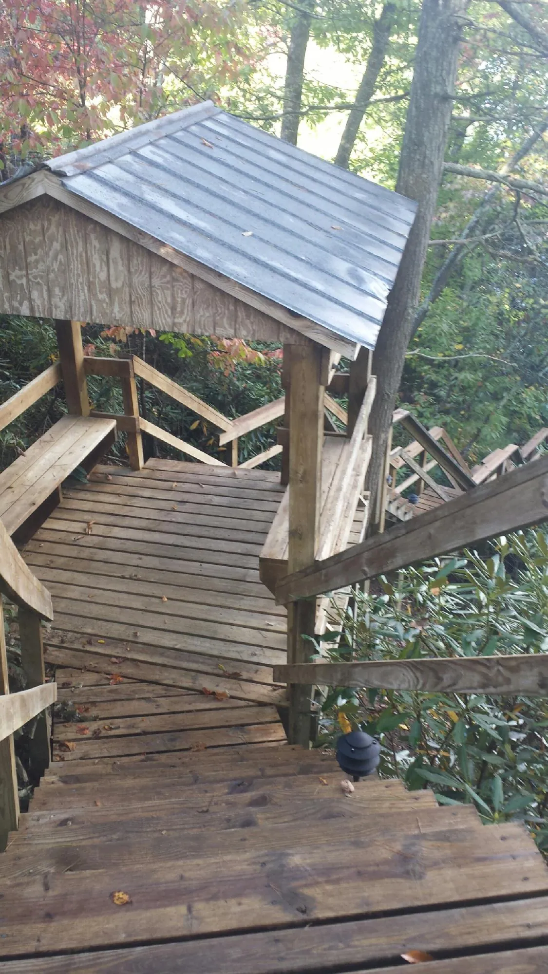 Metal roofed shelter over wooden steps on a wooded walkway — Skylight Repair & Installation work by our crew in Argos