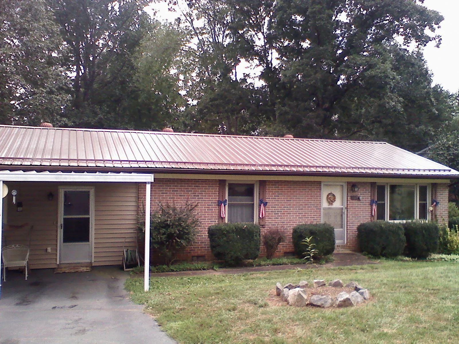 Bronze metal roof and carport on a brick ranch home — Roof Repair work by our crew in Argos